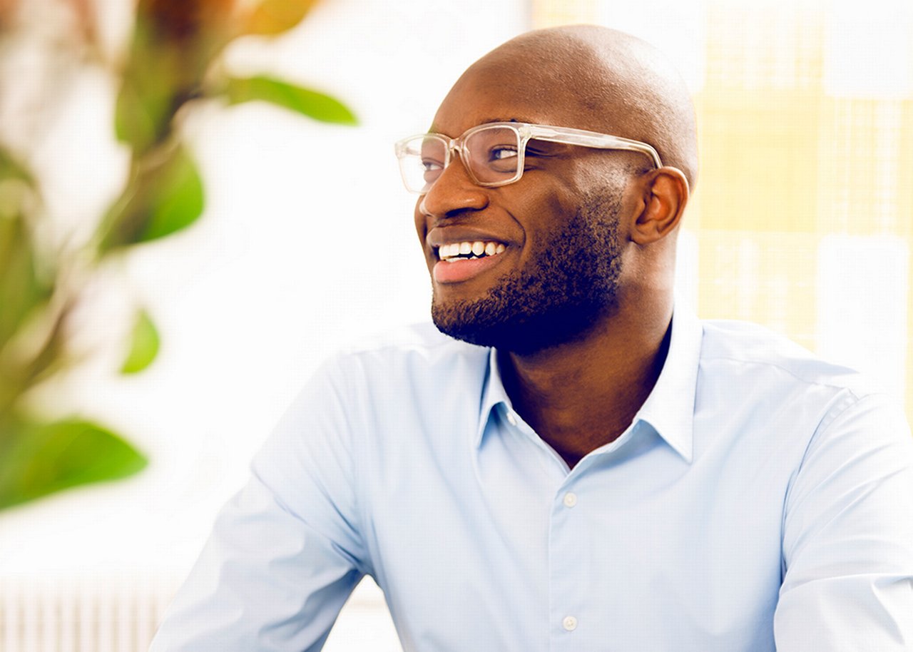 Kofi smiles; behind him a pointer