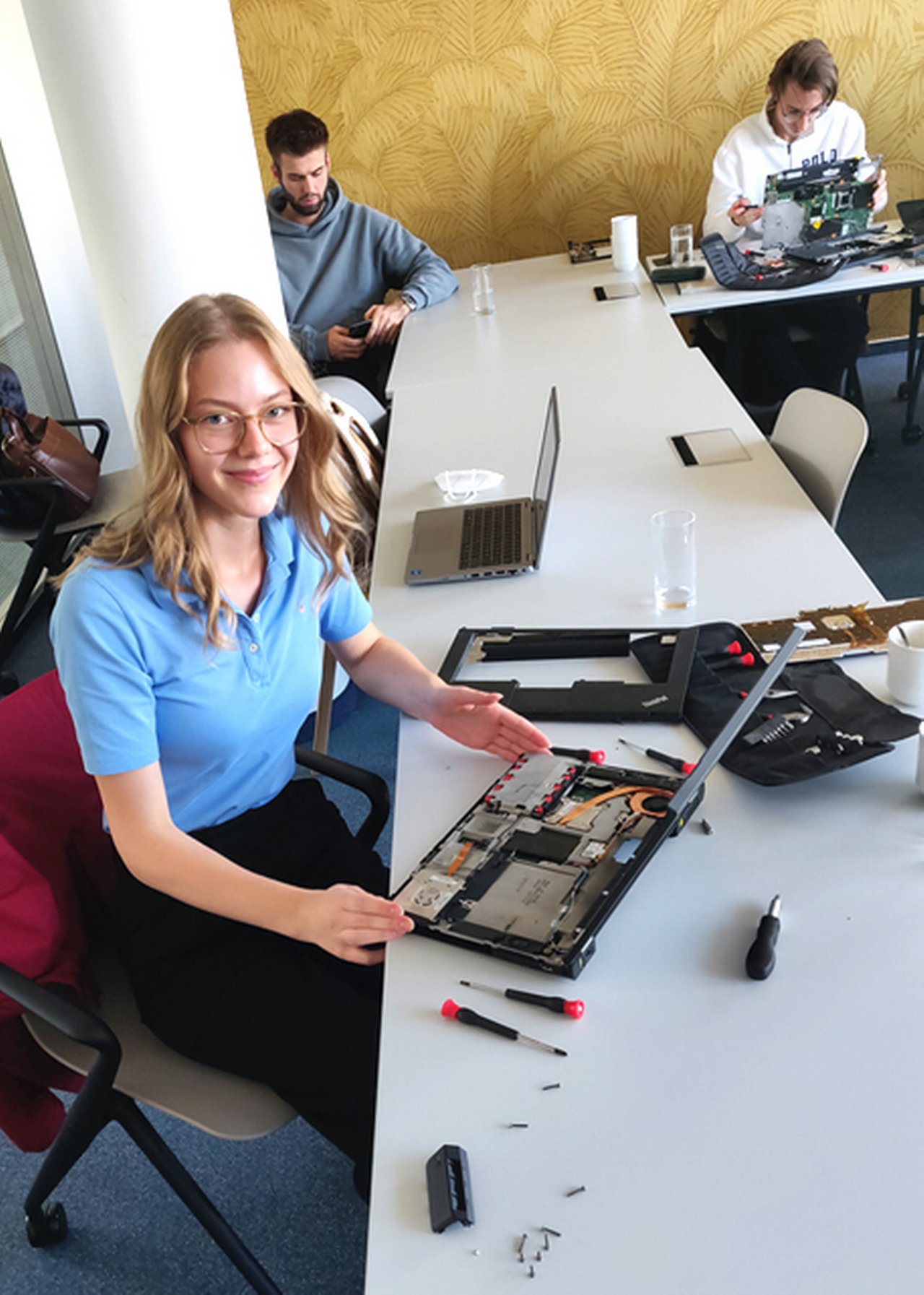 Nina am Schreibtisch mit Laptop und Schraubenzieher