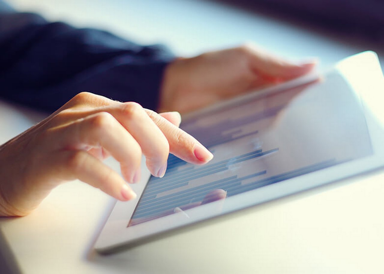 A female hand is typing on a tablet pc