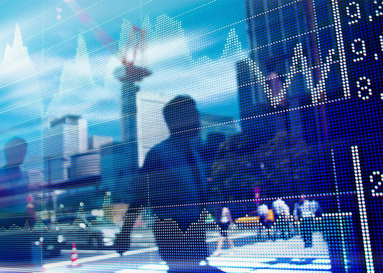 A man is reflected in a panel with stock market curves