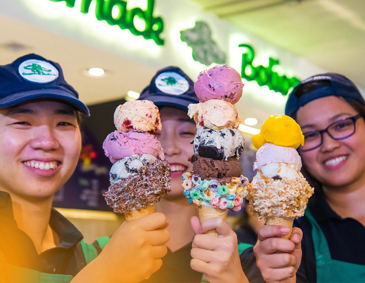Three colleagues each holding an Ice cream cone with different variety ice creams outside of an ice cream parlour