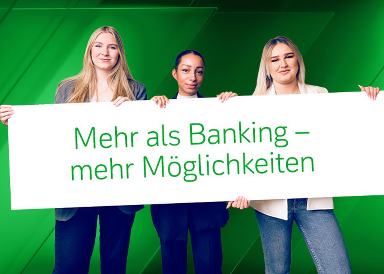 Azubis mit einem Schild ${esc.q}Mehr als Banking mehr Möglichkeiten${esc.q}