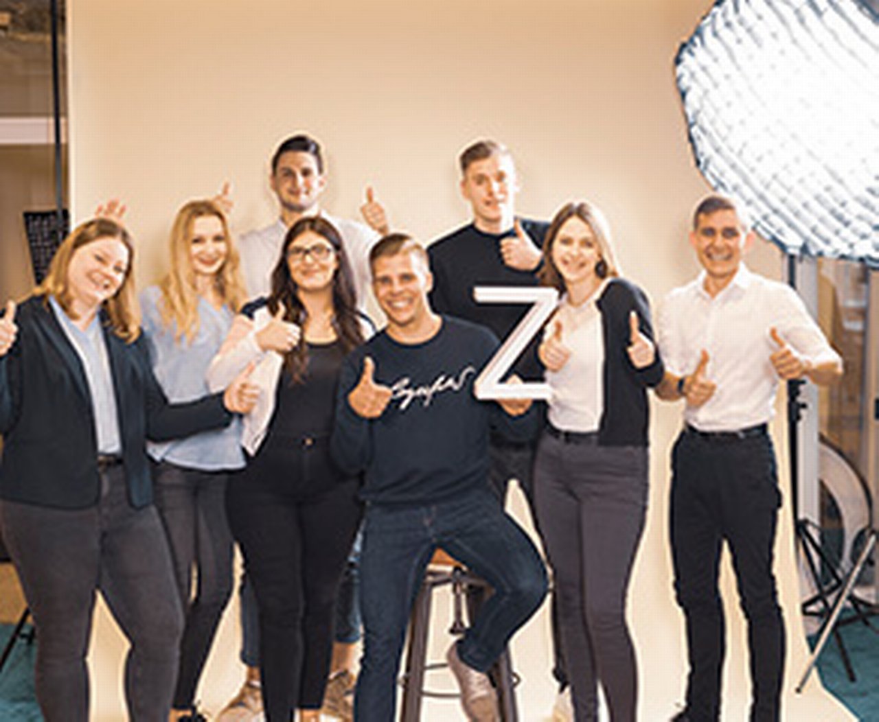 Azubis mit Daumen hoch während eines Fotoshootings
