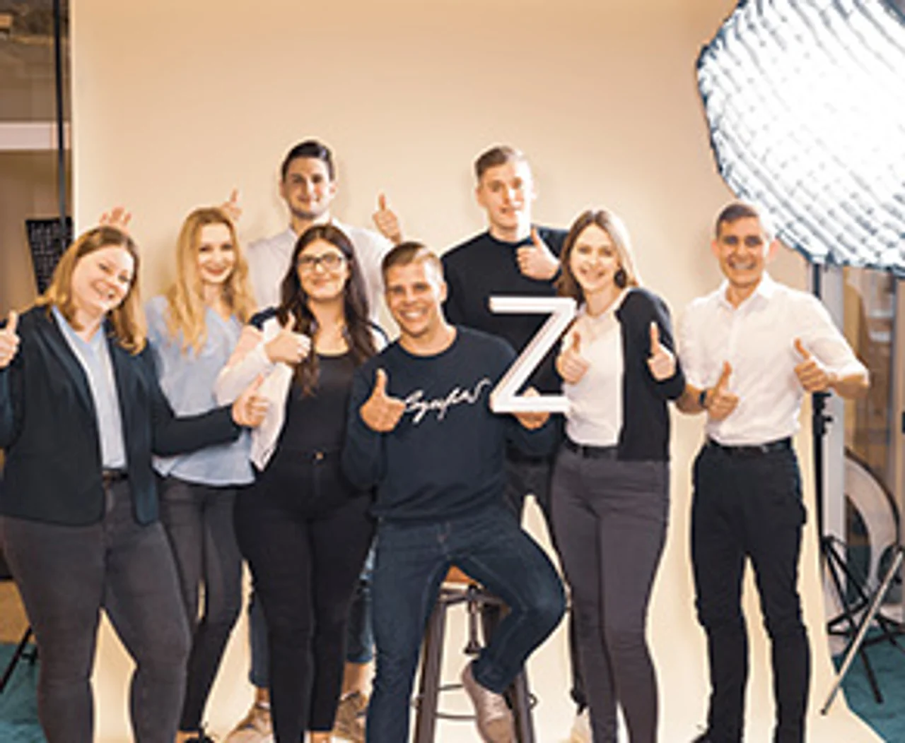 Azubis mit Daumen hoch während eines Fotoshootings
