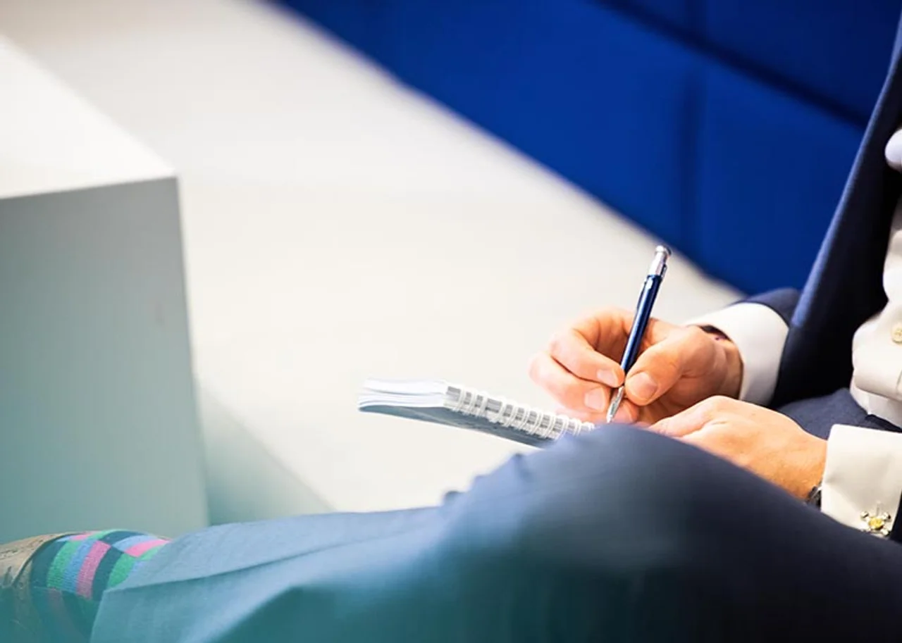 A person writes in a notepad