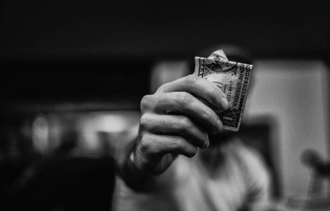 in black and white: hand with bank note